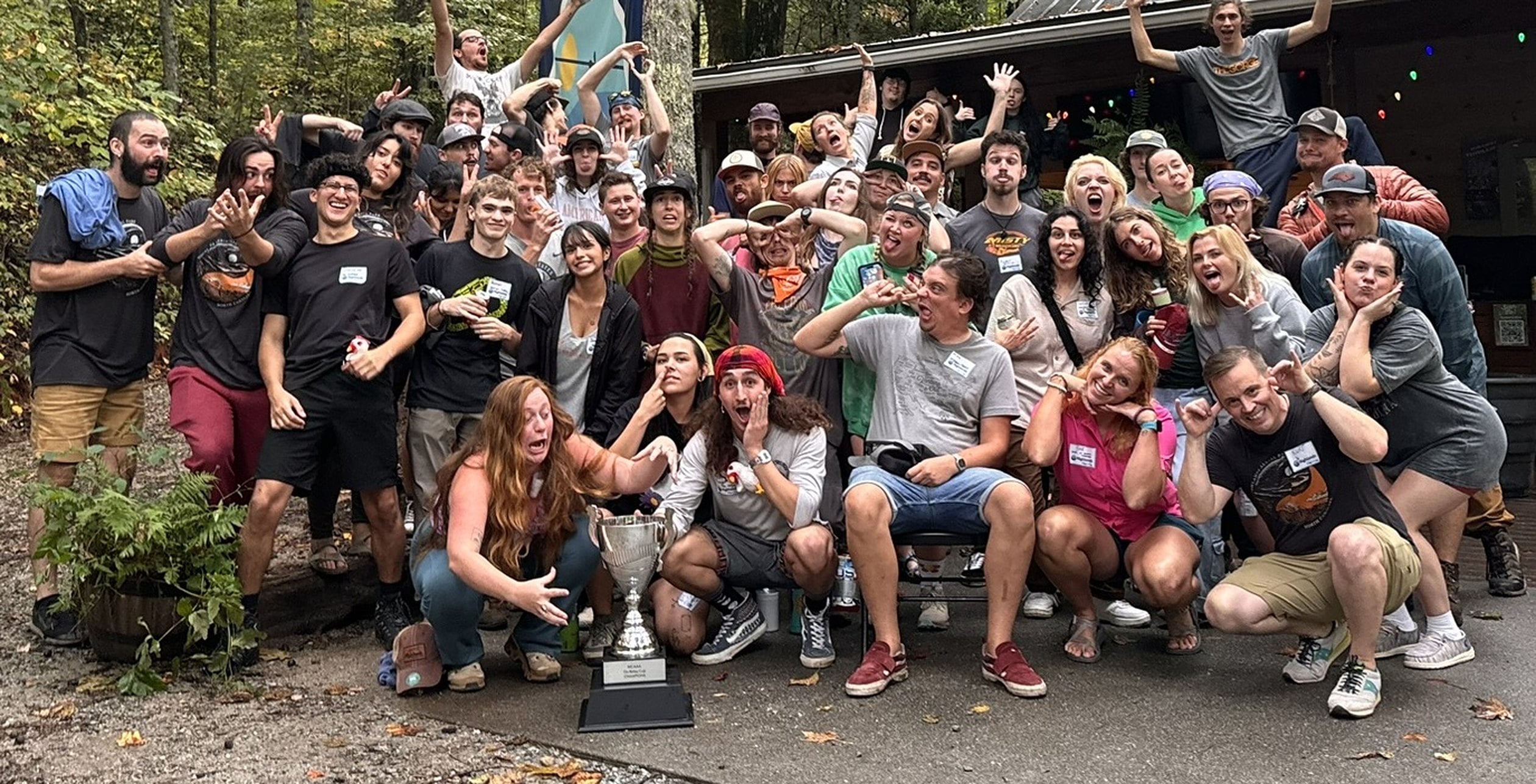 A large company group celebrating with a trophy at Highlands Aerial Park