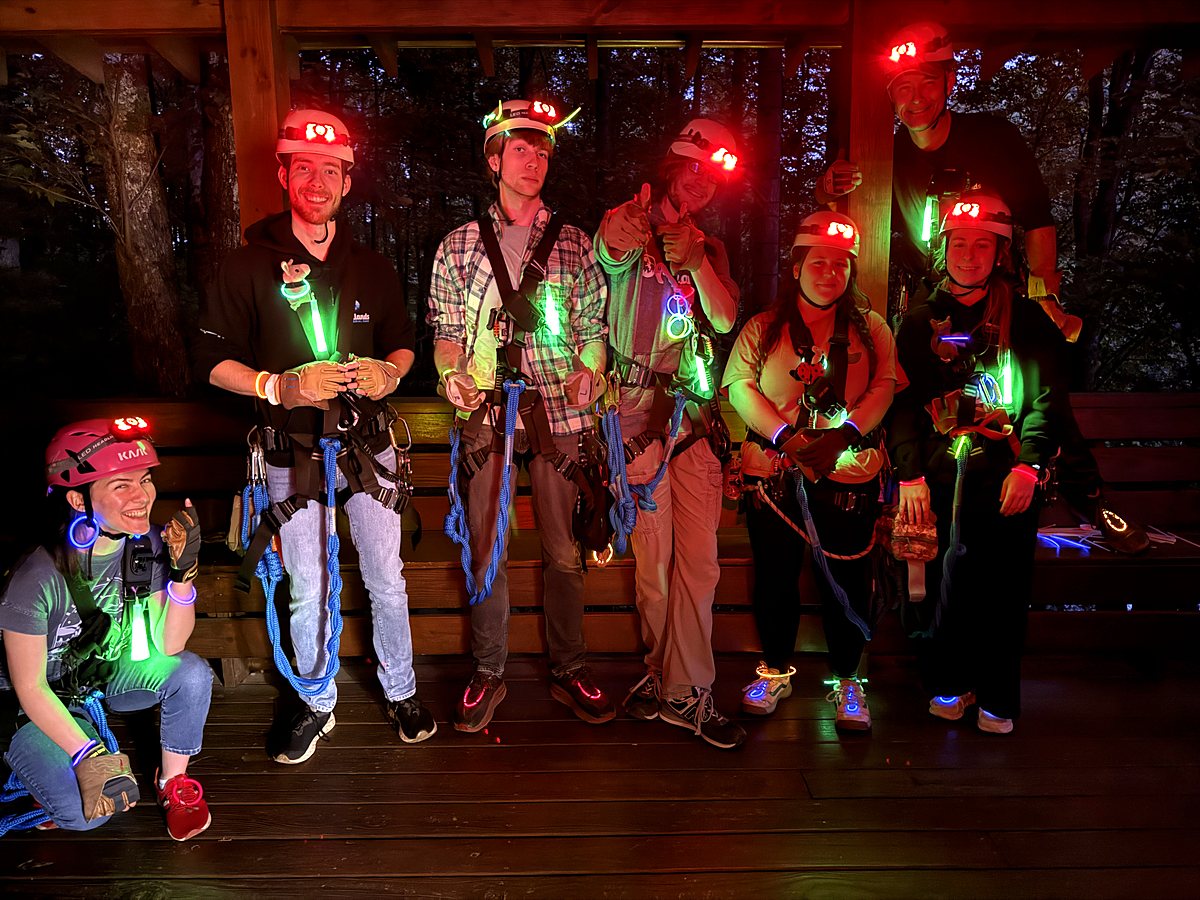 A Twilight Zip group geared up on the deck in headlamps and glow sticks